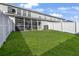 A fenced backyard with lush grass and a screened porch area for relaxing and entertaining at 8842 Gable St, North Charleston, SC 29406