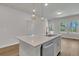 Well-lit kitchen features hardwood floors, stainless appliances, designer backsplash, and kitchen island at 930 Dusk Dr, Summerville, SC 29486