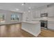 Well-lit kitchen features hardwood floors, stainless appliances, designer backsplash, and kitchen island at 930 Dusk Dr, Summerville, SC 29486