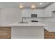 Open concept kitchen includes an island with stainless steel sink, quartz countertops and white cabinetry at 960 Dusk Dr, Summerville, SC 29486