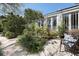 Landscaped backyard featuring white stone, lush greenery, and a bench near the back of the home at 99 Logan St, Charleston, SC 29401