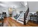 Bright living room with hardwood floors, exposed brick fireplace, and elegant staircase at 99 Logan St, Charleston, SC 29401
