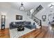 Inviting living room with a comfortable gray couch, hardwood floors, and staircase at 99 Logan St, Charleston, SC 29401