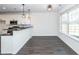 Modern kitchen with white cabinets, black countertops, stainless steel appliances and an island with pendant lights at 103 Rosa Gray Ln, Goose Creek, SC 29445
