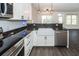 Bright kitchen features white farmhouse sink, stainless steel appliances, and wood-look flooring at 103 Rosa Gray Ln, Goose Creek, SC 29445