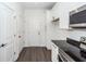 White kitchen features stainless steel appliances, black countertops, and dark wood-look flooring at 103 Rosa Gray Ln, Goose Creek, SC 29445