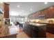 Modern kitchen with granite countertops, dark wood cabinets, a large island, and hardwood floors at 1067 Shipton Ct, Charleston, SC 29414