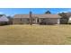 View of brick home's backyard with patio, grassy area, and brick chimney at 112 Lois Cir, Moncks Corner, SC 29461