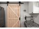 Close up of a rustic light wood sliding barn door with black hardware in the kitchen at 112 Lois Cir, Moncks Corner, SC 29461