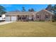 Charming brick home boasts a well-manicured lawn and inviting front porch with rocking chairs at 112 Lois Cir, Moncks Corner, SC 29461