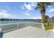 Lakeside backyard featuring a white deck and railings, green grass, and a mature palm tree at 1124 Clearspring Dr, Charleston, SC 29412