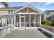 Exterior of a home showing a screened in porch with a deck, along with a mature palm tree at 1124 Clearspring Dr, Charleston, SC 29412