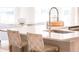 Bright kitchen island with a sink, modern faucet, and woven chairs with views of the dining area at 114 Snow St, Summerville, SC 29486