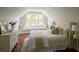 Bright bedroom features hardwood floors, a window seat with storage, and a comfortable bed with decorative pillows at 12 Elliott St # A, Charleston, SC 29401