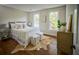 Bright bedroom with hardwood floors, plush rug, and ample natural light from large windows at 12 Elliott St # A, Charleston, SC 29401