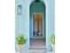 Elegant arched entrance with teal walls, potted ferns, and a glimpse of a staircase at 12 Elliott St # A, Charleston, SC 29401