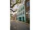 Charming teal townhome with black shutters and a covered entrance, nestled among historic buildings at 12 Elliott St # A, Charleston, SC 29401