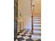 Elegant foyer with black and white tile, staircase, and stylish decor at 12 Elliott St # A, Charleston, SC 29401