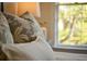 Bedroom pillows highlighting the comfortable textures, natural light, and outdoor views from the window at 12 Elliott St # A, Charleston, SC 29401