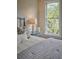 Comfortable bedroom featuring a bedside table with a stylish lamp and a large window with a green view at 12 Elliott St # A, Charleston, SC 29401