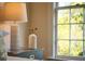 Bedroom side table featuring a modern lamp, elegant vase, and a large window overlooking the outdoors at 12 Elliott St # A, Charleston, SC 29401