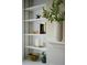 Built-in shelving unit adorned with decorative items and greenery at 12 Elliott St # A, Charleston, SC 29401