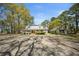 Spacious home with a wraparound porch and separate outbuilding, nestled among mature trees and ample parking at 1212 Pinopolis Rd, Moncks Corner, SC 29461
