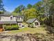 View of a light gray two-story home and separate gray outbuilding on a sunny day with lush landscaping at 1212 Pinopolis Rd, Moncks Corner, SC 29461