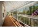 Covered porch with white railings and stained wood flooring, offering a tranquil view of the surrounding landscape at 1212 Pinopolis Rd, Moncks Corner, SC 29461
