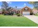 Beautiful brick home featuring a well-manicured lawn, two-car garage, and lovely landscaping at 1213 Waterfront Dr, Mount Pleasant, SC 29464