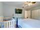 Bright bedroom featuring a crib, mounted TV, and neutral decor with wood-look flooring at 1257 Maryland Dr, Ladson, SC 29456