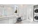 Bathroom featuring double sink vanity, marble floors, and a laundry room with a stacked washer/dryer at 136 Maritime Way, Summerville, SC 29485