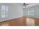 Bright bedroom featuring hardwood floors, white walls, and shuttered windows at 1369 Tidal Creek Cv, Charleston, SC 29412