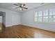 Bedroom with hardwood floors and white walls features a ceiling fan, closet, and windows at 1369 Tidal Creek Cv, Charleston, SC 29412