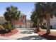 Beautiful brick home with a three-car garage, surrounded by lush palm trees and a red mulch driveway at 1369 Tidal Creek Cv, Charleston, SC 29412