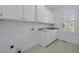 Laundry room featuring white cabinets, granite countertops, a sink, and a window at 1369 Tidal Creek Cv, Charleston, SC 29412