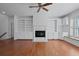 Living room showcasing custom built-ins, fireplace, hardwood floors, and bright windows at 1369 Tidal Creek Cv, Charleston, SC 29412
