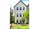 A striking three-story home featuring a painted brick facade, complemented by black framed windows and professional landscaping at 1510 Cecile St, Mount Pleasant, SC 29464