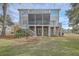 Home's back exterior featuring a screened-in porch, patio and lawn with mature landscaping at 1626 Bull Creek Ln, Charleston, SC 29414