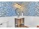 Stylish powder room features blue wallpaper, wooden vanity, and classic fixtures at 1626 Bull Creek Ln, Charleston, SC 29414