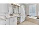 Bright bathroom features a double sink vanity, tub, seated vanity, and natural light at 1626 Bull Creek Ln, Charleston, SC 29414