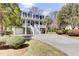 Elegant two-story home with grand entrance, featuring a covered porch and beautiful landscaping at 1626 Bull Creek Ln, Charleston, SC 29414