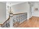 Upstairs hallway with hardwood floors, ornate staircase, and classic lighting at 1626 Bull Creek Ln, Charleston, SC 29414