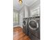 Bright laundry room with side-by-side washer and dryer and hardwood floors at 1626 Bull Creek Ln, Charleston, SC 29414