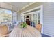 Comfortable screened porch with a wooden dining set, inviting seating, and view into the living room with fireplace at 1626 Bull Creek Ln, Charleston, SC 29414