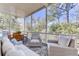 Relaxing screened porch with comfortable seating, stylish decor, and wooded backyard views at 1626 Bull Creek Ln, Charleston, SC 29414