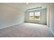 Large bedroom with neutral carpet, tray ceiling, and windows offering neighborhood views and natural light at 197 Belfort Pl, Summerville, SC 29486