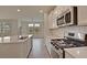 Modern kitchen with stainless steel appliances, island with sink, and lots of natural light through large windows at 197 Belfort Pl, Summerville, SC 29486