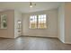 Bright living room with wood-look flooring, multiple windows, and an entry way to the backyard at 197 Belfort Pl, Summerville, SC 29486