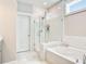 Bright bathroom featuring a glass-enclosed shower, soaking tub, and white subway tile at 1984 Shadetree Blvd, Johns Island, SC 29455